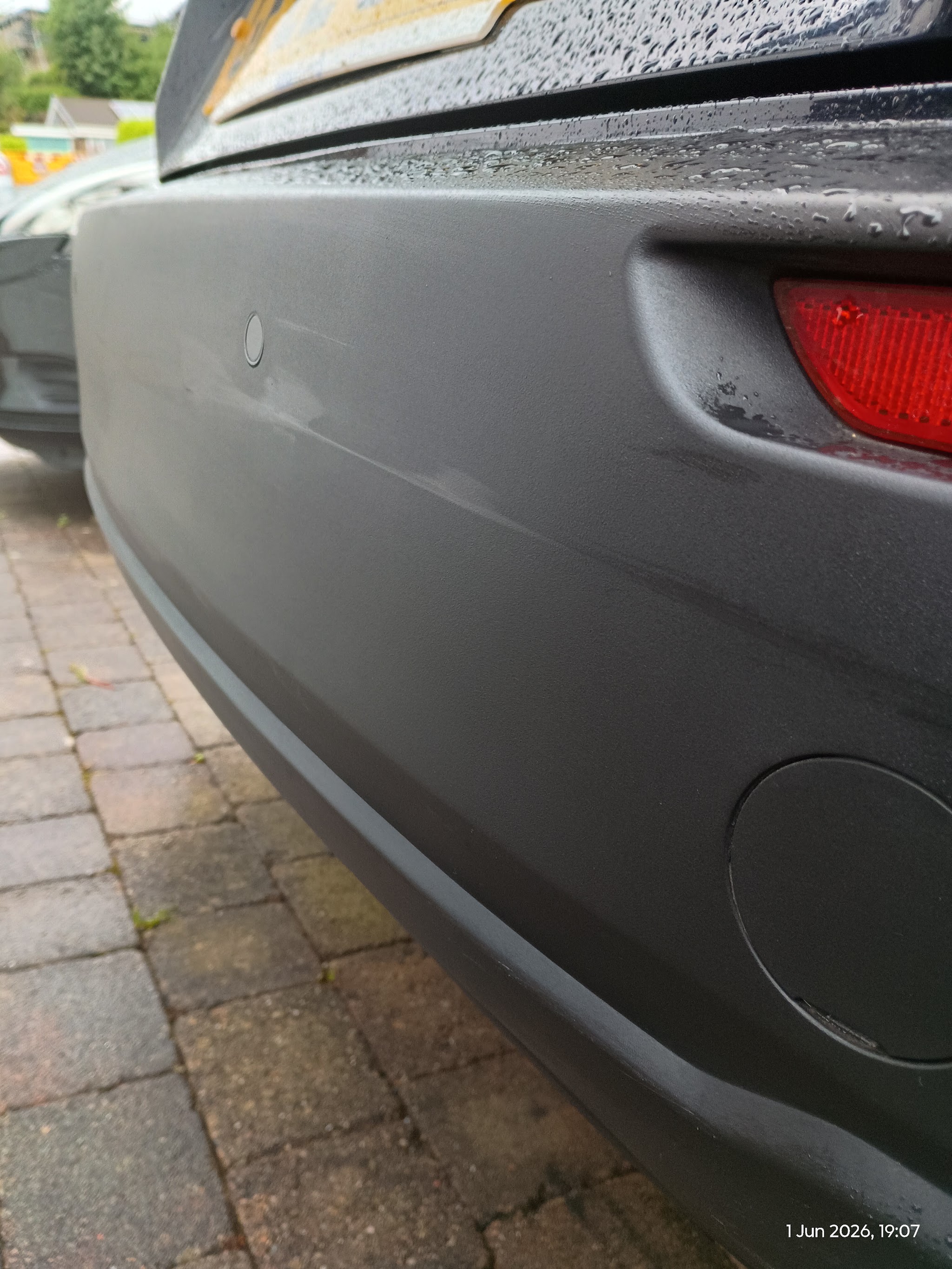 Dark grey textured rear bumper after rain